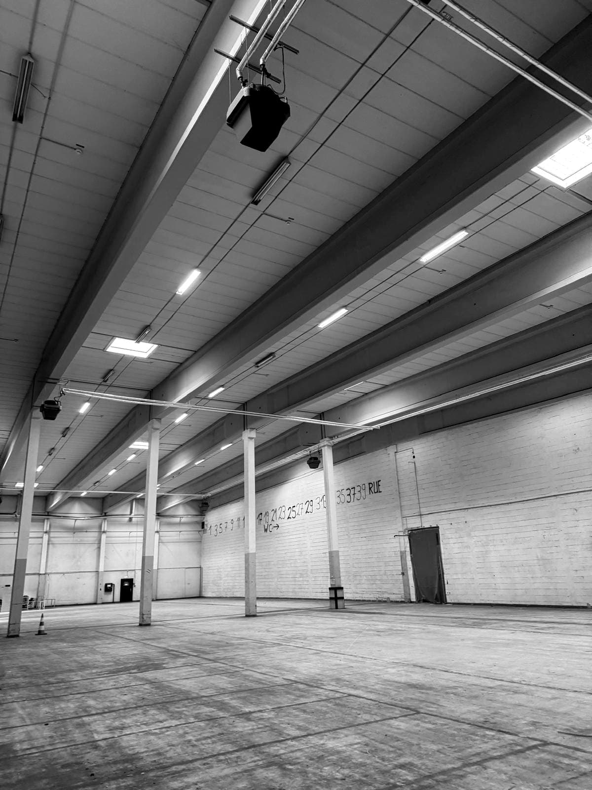 Die leere Halle in Empelde vor dem Umbau: hohe Decke mit Oberlichtern, Säulen und Betonboden